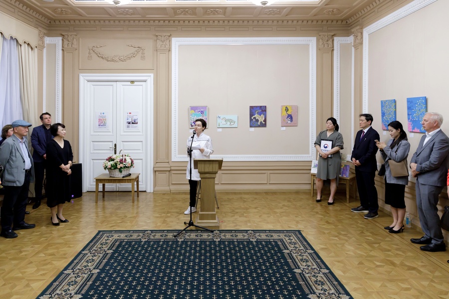 ▲ Елена Хохлова знакомит гостей вернисажа с живописью минхва